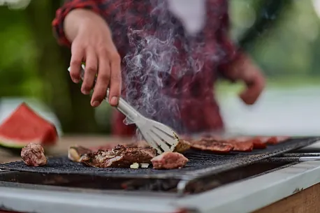 enfoque selectivo de mano agarrando pedazo de carne con pinzas